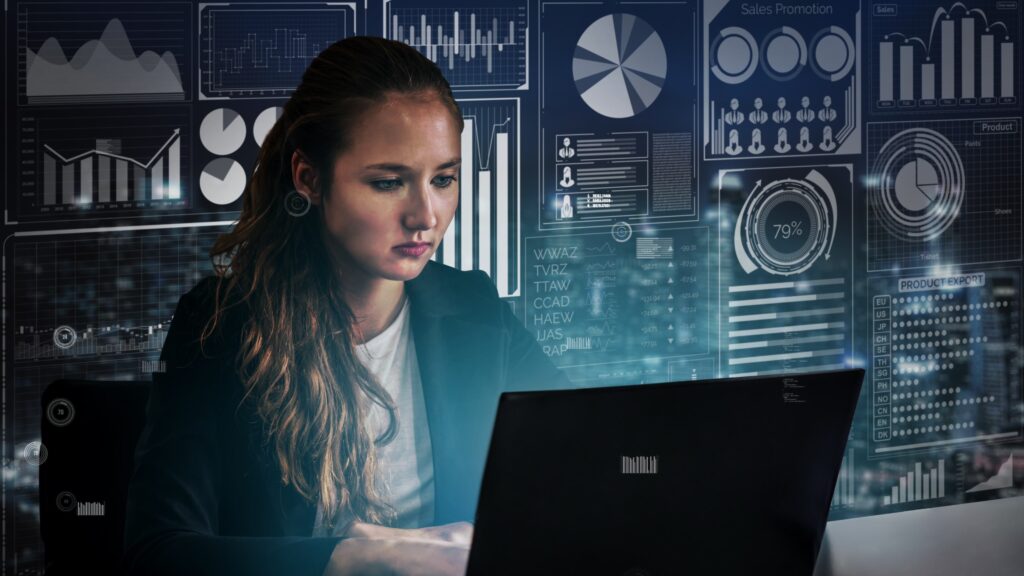 A focused woman works on a laptop surrounded by digital data charts and graphs. The scene conveys a high-tech and analytical atmosphere.