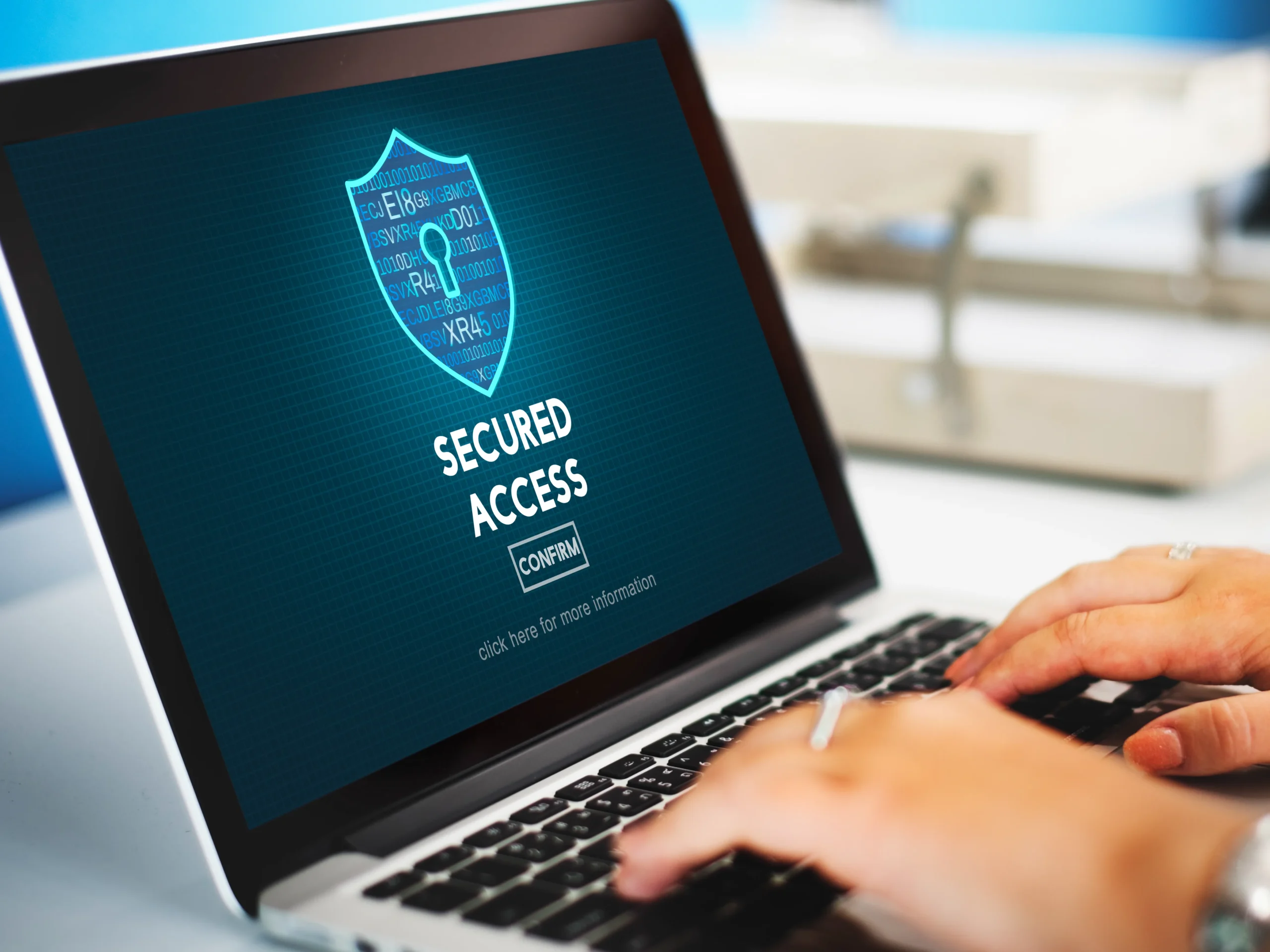 Hands typing on a laptop with a "Secured Access" screen. A digital shield with a keyhole icon symbolizes cybersecurity, conveying safety and protection.Cyber protection,netsectechnologies
